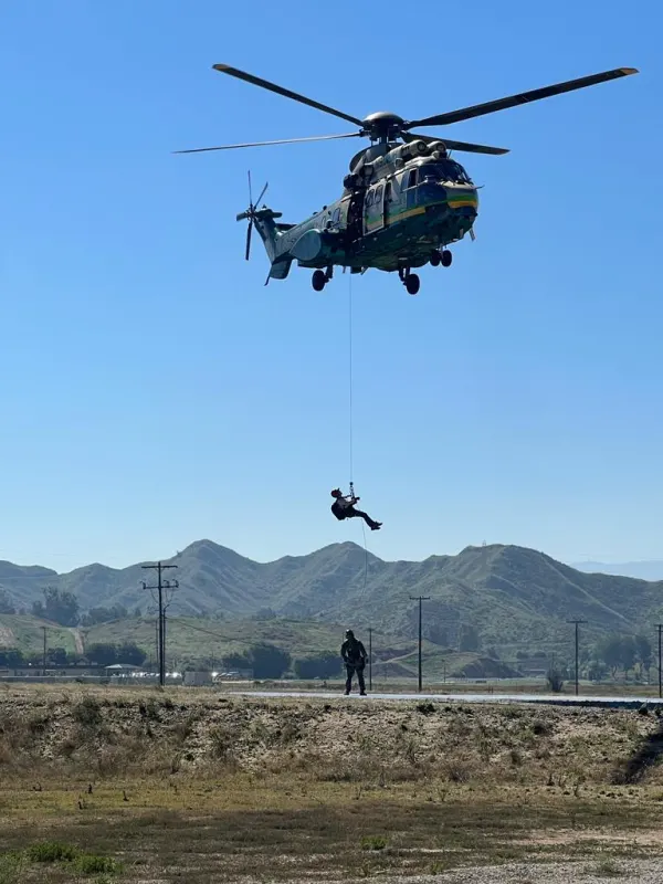 A rescuer hoisted beneath a Sheriff's helicopter
