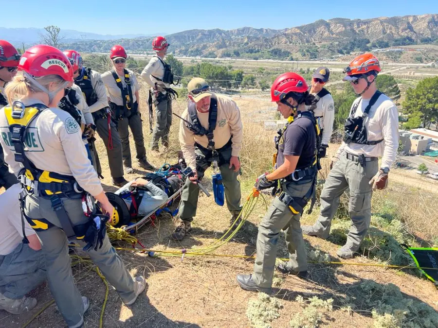 Team members packaging a patient in a litter during training