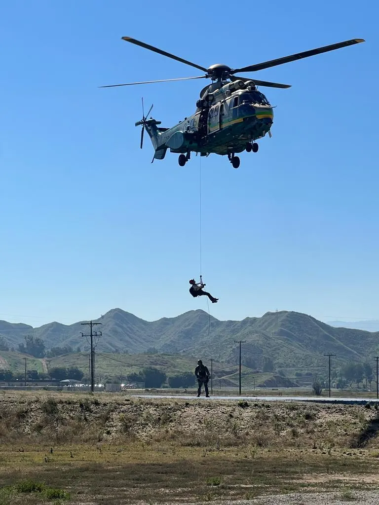 A rescuer being hoisted to a Sheriff's helicopter